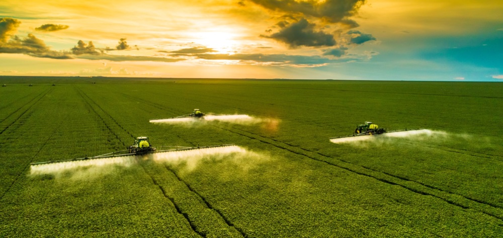 Industrial fertilizer application at sunset.